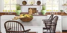 a kitchen filled with lots of counter top space and wooden chairs next to a sink