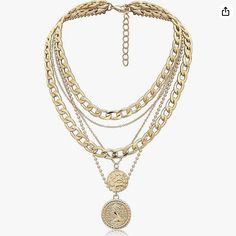 a gold layered necklace with a coin on the front and two chains around it,