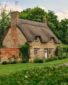 an old brick house with a thatched roof