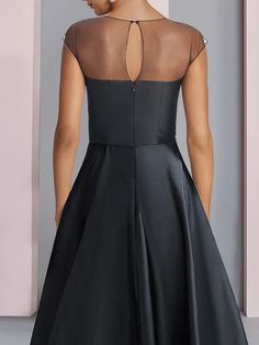 the back of a woman's dress with sheer neckline and illusional detailing