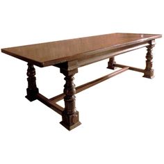 a large wooden table with two legs and a long slab on one end, sitting against a white background