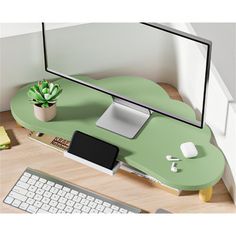 a computer desk with a monitor, keyboard and phone on it next to a cactus