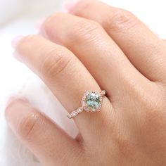 a woman's hand with a ring on it and an aqua stone in the middle