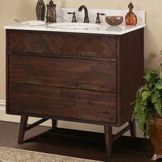 a bathroom vanity with two sinks and wooden drawers next to a potted plant on the floor