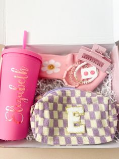 a pink and white checkered purse next to a cup