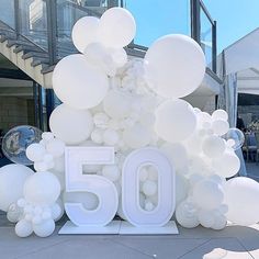 the number 50 is surrounded by white balloons