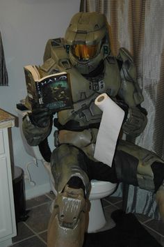 a man in a costume sitting on a toilet reading a book