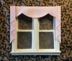 an old window with pink trim on the top and bottom, in front of a floral wallpaper