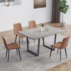 a dining table with four chairs and a vase on the table in front of it