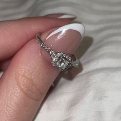 a close up of a person's hand with a diamond ring on their finger