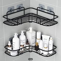 two black metal shelves with soaps, lotions and other items on them in the corner of a tiled bathroom