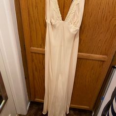 a white dress hanging on a wooden door