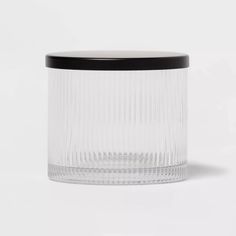 an empty glass container with a black lid