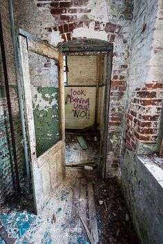 an old run down room with graffiti on the door