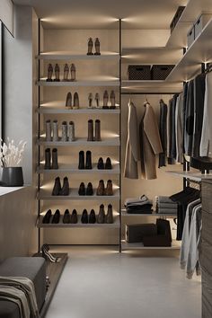 a walk in closet filled with lots of shoes and clothing hanging on the wall next to shelves