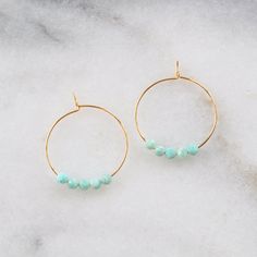 These sweet tiny amazonite hoops are the perfect style to wear every day. Bonus: Amazonite is a beautiful blue-green stone known for it's heart chakra cleansing power -- meaning it'll help rid you of yucky toxic emotions. 25mm (about 1") gold-plated or silver-plated hoops 3mm Amazonite beads packaged on a hand-stamped kraft earring card in a clear resealing bag Not sure which gemstone to choose? This blog post might help: Get Your Woo-Woo on with Gemstone Jewelry Chakra Cleansing, Amazonite Earrings, Chakra Cleanse, Woo Woo, Earring Card, Earring Cards, Perfect Style, Green Stone, Heart Chakra