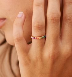 Meet our Rainbow Band Ring- this whimsical piece is adorned with an arc of meticulously selected CZ stones, each shimmering with the joyous hues of the rainbow. Perfect for the color-loving daydreamer, this ring is more than an accessory—it's your very own piece of wearable joy. Multicolor Jewelry As A Gift, Adjustable Rainbow Stackable Jewelry, Adjustable Rainbow Gemstone Ring, Adjustable Multi-stone Rainbow Jewelry, Adjustable Rainbow Birthstone Jewelry, Multicolor Halo Rings As A Gift, Multicolor Halo Rings For Gift, Elegant Adjustable Rainbow Rings, Multicolor Halo Ring As Gift