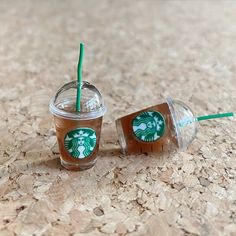 two starbucks cups sitting on top of a table