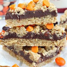 three pieces of cookie bars stacked on top of each other with candy candies around them