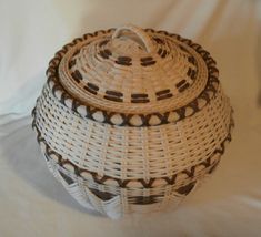 a white wicker basket sitting on top of a bed