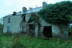 an old stone building with ivy growing on the roof