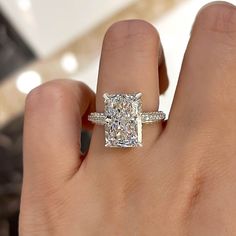 a woman's hand with a diamond ring on top of her finger and the engagement band