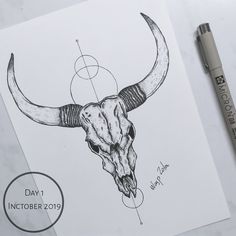 an ink drawing of a bull's skull with long horns on paper next to a marker