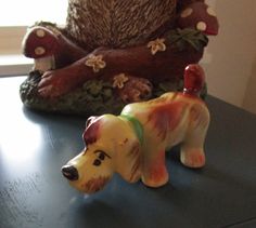 a small dog figurine sitting on top of a table next to a bear statue