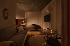 a dimly lit room with a couch, table and chair in it's corner