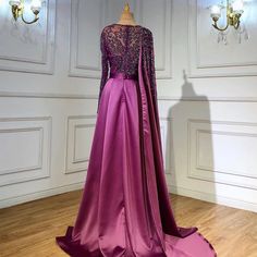 Gorgeous Grape Hue: A rich grape purple color that exudes sophistication and allure, making it an ideal choice for evening events and parties in 2024 . Elegant Silhouette: The dress boasts an elegant silhouette that drapes beautifully, enhancing your natural grace and charm. High Split: A high split in the skirt adds a touch of sensuality and allows for ease of movement, perfect for dancing and making a grand entrance. Luxurious Satin Fabric: The gown is crafted from luxurious satin fabric, addi Purple Long Sleeve Dress For Mother Of The Bride, Purple Long Sleeve Mother Of The Bride Dress, Purple Long Sleeve Banquet Gown, Long Sleeve Purple Gown For Banquet, Purple Mother Of The Bride Dress With Sweep Train, Long Sleeve Purple Banquet Gown, Purple Long Sleeve Gown With Sweep Train, Glamorous Purple Gown For Banquet, Glamorous Purple Banquet Gown