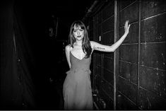 a black and white photo of a woman in a dress with her arms stretched out