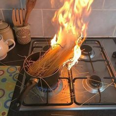 a pot on top of a stove with spaghetti in it's burner and flames coming out