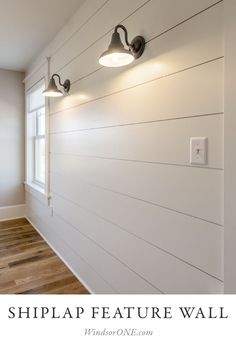 the shiplap feature wall is painted in white and has two lights on each side