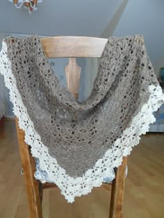 a wooden chair with a crocheted shawl on it