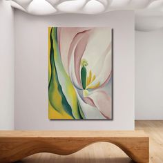 an abstract painting hangs on the wall above a wooden bench