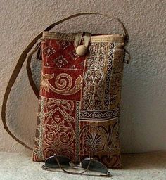 a small purse sitting on top of a counter next to a pair of sunglasses and a string