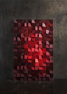 an abstract painting made out of red cubes on a black surface with a dark background