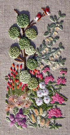 an embroidered piece of art with flowers on it