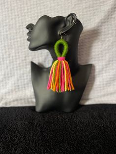 a black mannequin head with colorful tassels on it