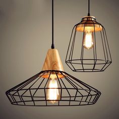 two light fixtures hanging from the ceiling with wooden accents and wire caged lightshades