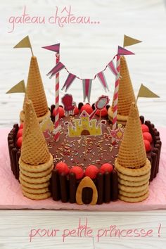 a birthday cake with chocolate frosting and cones on top, surrounded by confetti