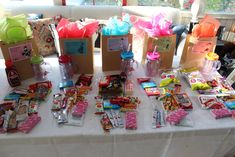 the table is full of candy and gift bags for children to use on their birthday party