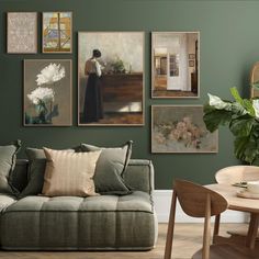 a living room with green walls and paintings on the wall, including a couch in front of a coffee table