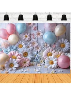 an image of balloons and flowers on the wall in front of a white brick wall