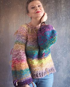 a woman wearing a multicolored sweater posing for the camera