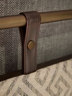 a close up view of the handles on a bed frame with fabric and leather accents