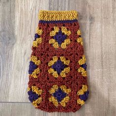 a crocheted pot holder on a wood floor