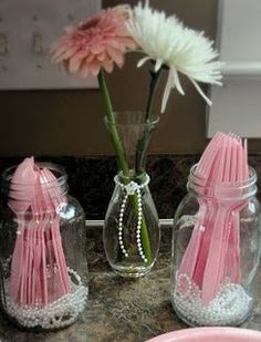 two vases with flowers in them sitting on a table