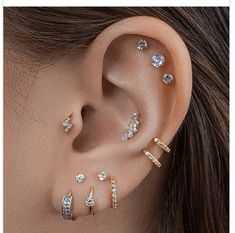 a woman's ear with five different types of piercings