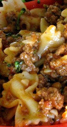 pasta with meat and vegetables in a red bowl